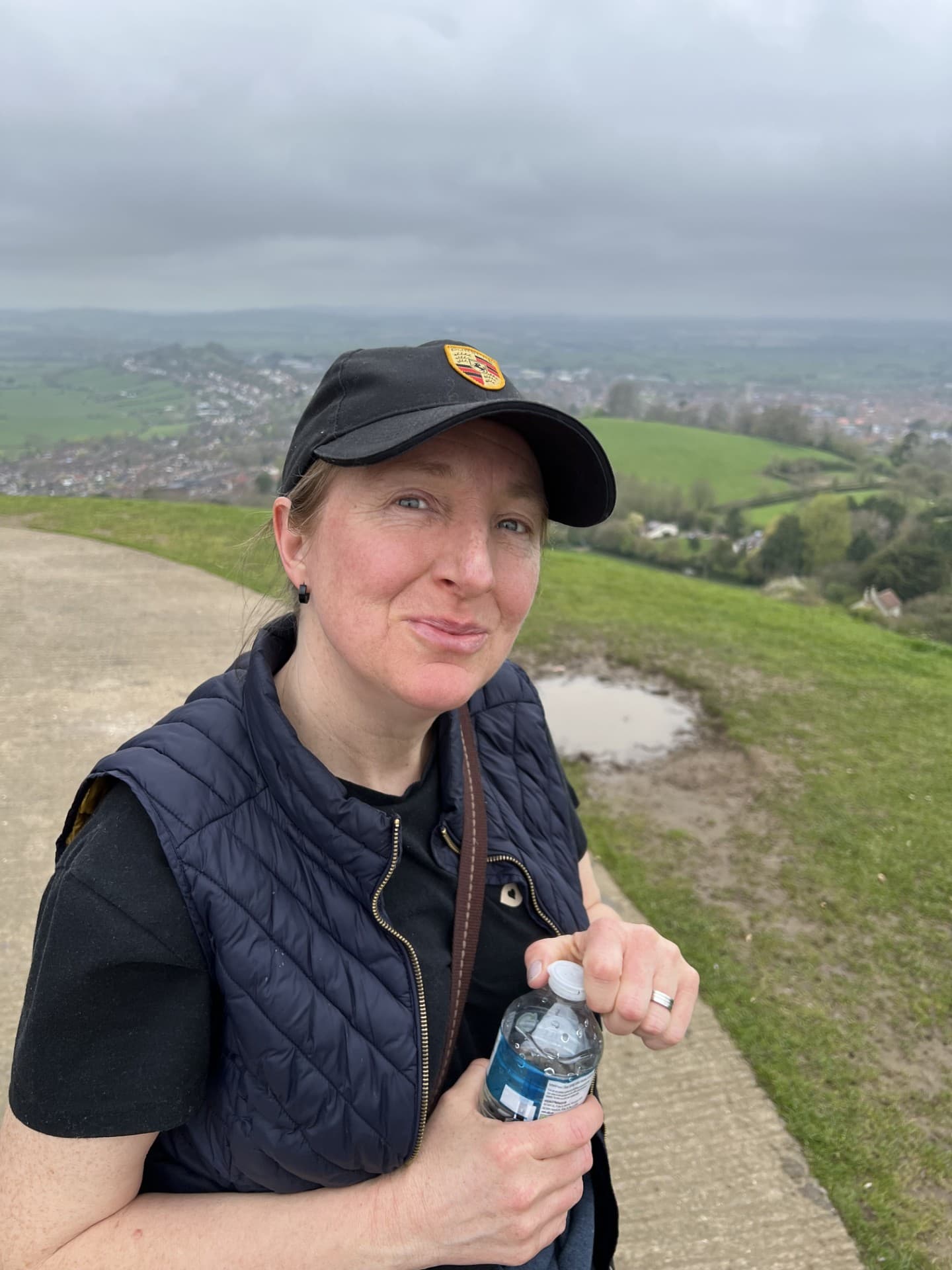 Zoe outdoors on a hill, holding a bottle of water.